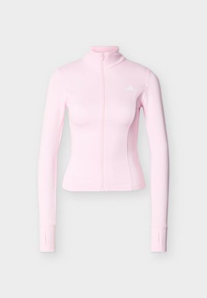 Αθλητικό μπουφάν σε ανοιχτό ροζ χρώμα, με μακριά μανίκια, πλήρης φερμουάρ μπροστά και τρύπες για τους αντίχειρες, με μικρό αντανακλαστικό λογότυπο στο αριστερό στήθος.