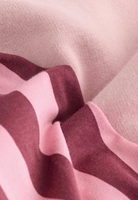 Dziana tkanina o miękkiej fakturze; zawiera naprzemienne paski w jasnoróżowych i głęboko burgundowych odcieniach. Gładka powierzchnia, lekka i elastyczna.