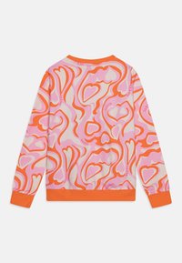 Kolorowy sweter z abstrakcyjnym wzorem serca w odcieniach różu, pomarańczu i kremu. Posiada pomarańczowe mankiety i wykończenie. Materiał wydaje się być miękki i teksturowany.