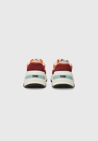 Red and orange suede and mesh sneakers with a black sole, white midsole, and blue accents. "DIESEL" logo on the heel. Rounded design.