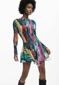 Színes hosszú ujjú ruha absztrakt mintával. Testhezálló felsőrész és bővülő szoknya jellemzi. Könnyű, selymes anyagból készült.