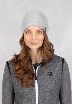 Gray knitted beanie with a smooth texture and a small brown tag. Paired with a dark gray zip-up vest featuring a round logo patch.