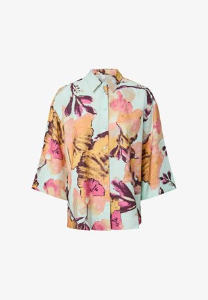 Korte mouwen overhemd met knopen en een oversized bloemmotief in pastelkleurig roze, geel en paars op een lichtblauwe achtergrond.