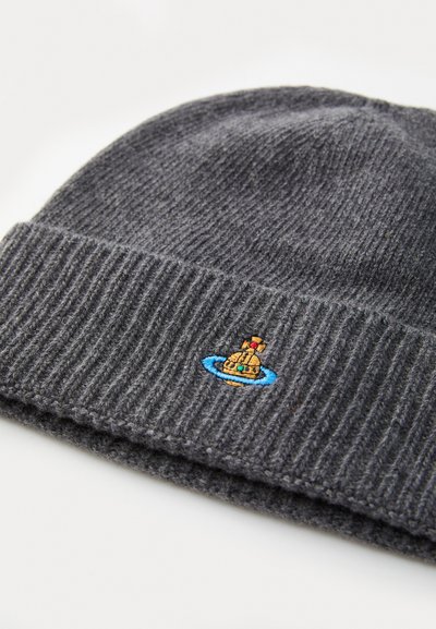 Pilkos megztos beanie kepurės suغرiebtu audiniu, ant kurios pavaizduota maža siuvinėta povandeninio laivo su periskopu iliustracija, pabrėžta mėlynais ir auksiniais akcentais.