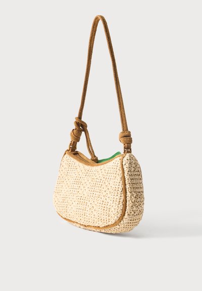 Μικρή μπεζ πλεκτή τσάντα ώμου με καφέ διακόσμηση σουέτ και δεμένο λουράκι, μερικώς ανοιχτή που δείχνει πράσινο ύφασμα στο εσωτερικό.