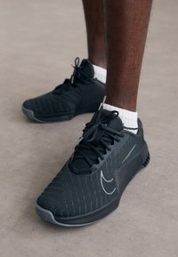 Svarta sprintskor med ovandel i mesh, texturerade sidopaneler och gummisula. Utrustad med snörning och en subtil logotypdetalj.