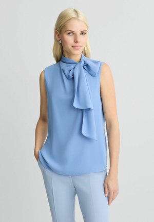 Blusa senza maniche di colore azzurro chiaro con dettaglio al collo a cravatta, realizzata in tessuto morbido, con una vestibilità rilassata e un orlo arrotondato.