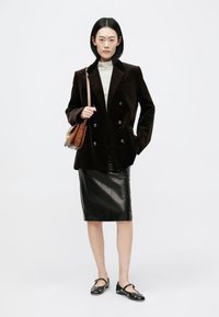 Brun fløjl dobbeltbrystet blazer, sort læder blyantskørt, gråstribet turtleneck, brun taske, sorte flade sko med dekorative detaljer.