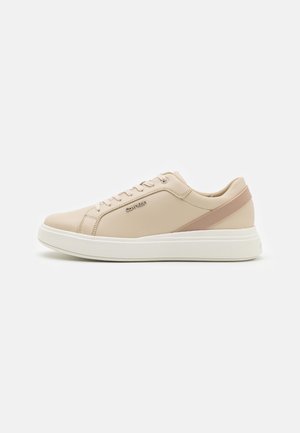 Sneakers in pelle sintetica beige con suola bianca, caratterizzate da una striscia di accento rosa e lacci rotondi per una vestibilità sicura e un design moderno.