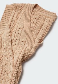 Beige ärmelloser Pullover aus Kabelstrick mit gerippten Abschlüssen. Verfügt über strukturierte Muster, weiches Material und ein V-Ausschnitt-Design.