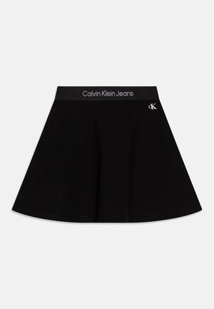 Sort A-line nederdel med elastisk talje med teksten "Calvin Klein Jeans" og lille hvid "cK" logo på øverste højre side.