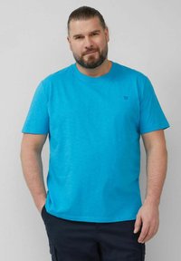 Kurzärmliges, Rundhals-T-Shirt in lebhaftem Türkis. Hergestellt aus leichtem Gewebe mit einer dezenten Textur. Kleines Logo auf der Brust.