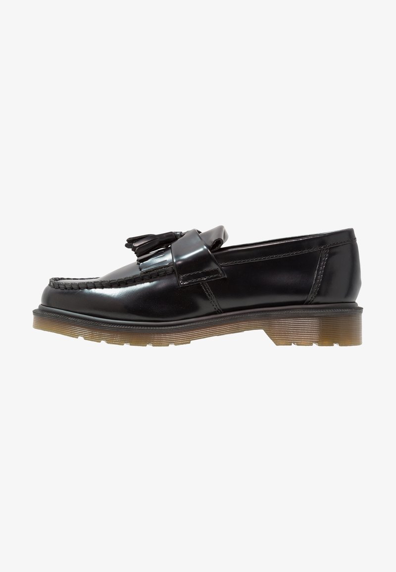 Musta patentinahkainen loafers-kengät, joissa on punottu muotoilu, tupsuaksentti ja paksu, teksturoitu kumipohja. Sivuprofiili korostaa tyylikästä siluettia.