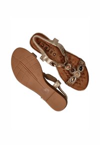 Goudkleurige sandalen met een gestructureerde inlegzool, versierd met decoratieve stenen, een verstelbare band en een rubberen loopzool met grippatroon.