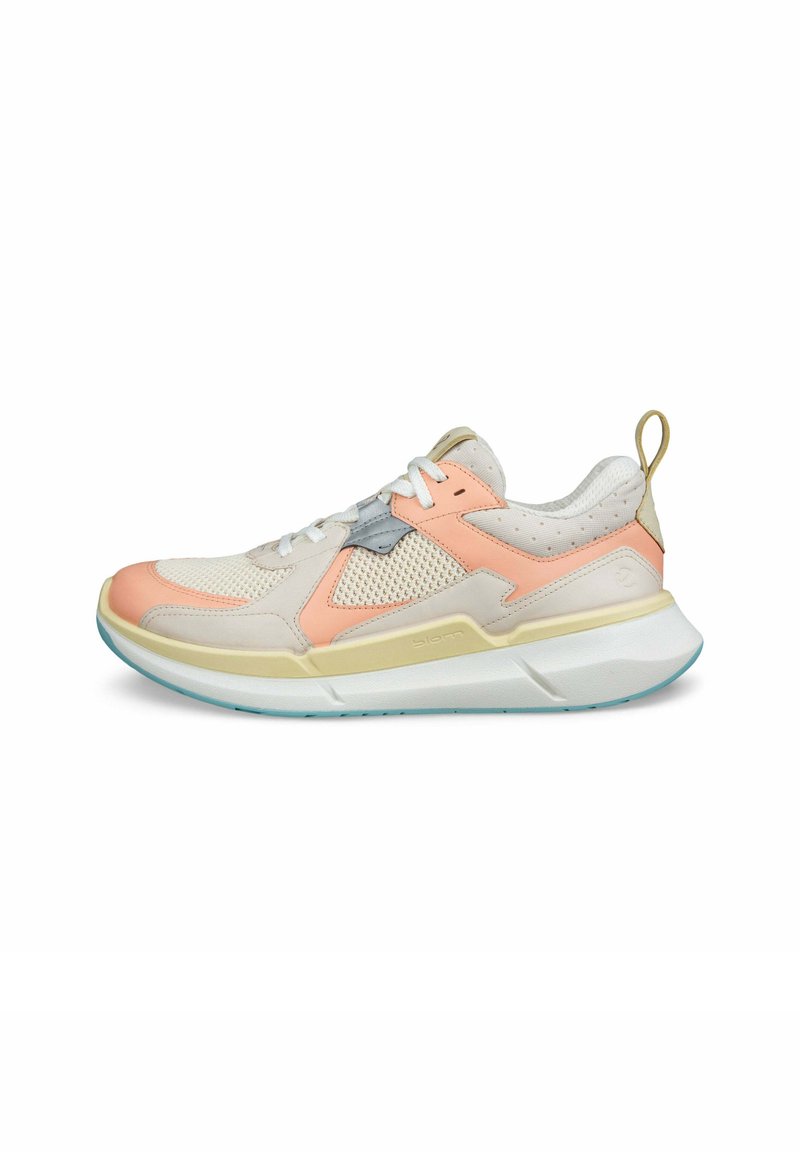 Baskets de sport avec une tige en maille et en daim dans les tons beige, rose et gris clair. Présentent une semelle texturée et une languette au niveau du talon.
