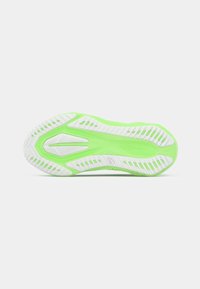 Suela de zapato con una combinación de colores blanco y verde claro, que presenta un diseño texturizado con surcos, crestas y orificios de drenaje para mayor tracción.