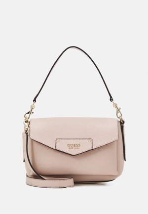 Helle beige Guess-Handtasche aus Leder mit oberer Klappe, goldenem Logo-Schild, schwarzer Besatz, abnehmbarem Schulterriemen und kurzem Tragegriff.