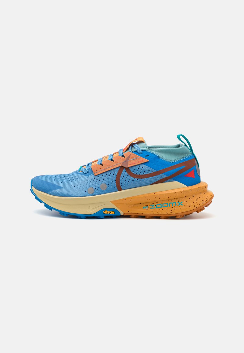 Lyseblå løbesko med orange accenter, åndbart mesh-overdel, og kraftig sål med spraglet detaljer og Vibram-mærkning.