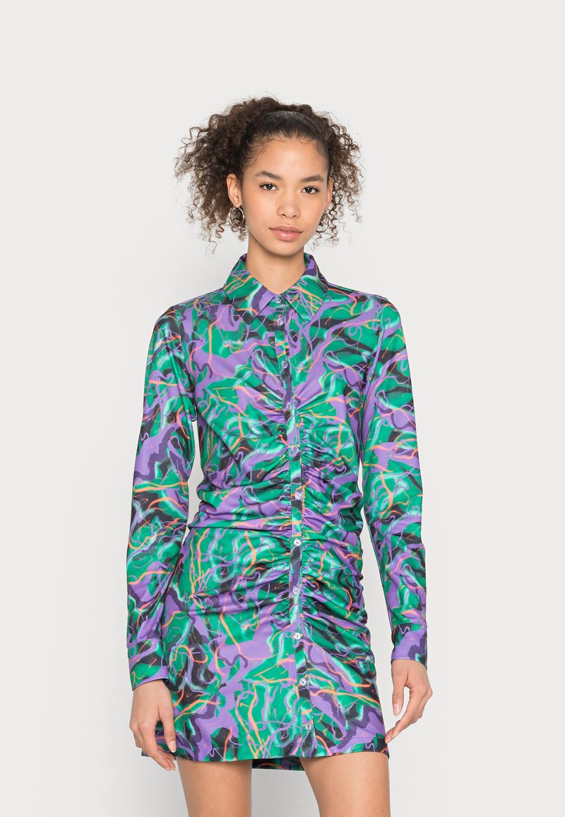 Vestido de manga longa, com franzidos, em padrões abstratos vibrantes de verde, roxo e preto. Tecido suave e liso com fecho de botão na parte da frente.