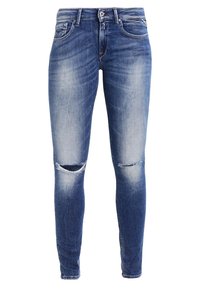 Smal passform jeans i ljusblå denim, med urtvättade områden och två knäskärningar, klassisk femfickdesign och dragkedja.