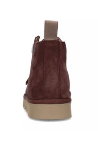 Stivaletto in suede marrone con finitura testurizzata, dotato di suola in gomma beige e di un pratico laccio per facilitare l'indossamento.