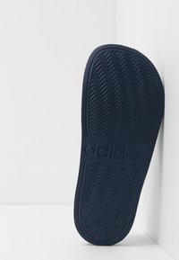 Marine rubber schoenzool met een visgraatprofiel en "adidas" branding, met een gladde textuur en afgeronde randen.