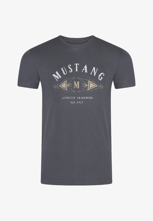 T-shirt en coton gris avec un col rond et des manches courtes. Le design à l'avant comprend "MUSTANG" et des motifs dans des tons crème et or.