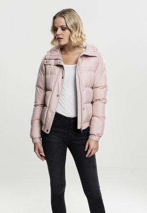 Lys rosa boblejakke med avtakbar hette, knapper og glidelås-lukking, samt ribbadde mansjetter. Bært over en hvit topp og svarte jeans.
