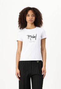 T-shirt bianco in cotone a maniche corte con testo nero "Rebel" e logo "PATRIZIA PEPE" sottostante. Tessuto morbido, colletto a girocollo.