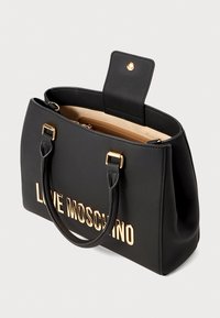 Must aksaga mustrida mustrida koos kuldse "LOVE MOSCHINO" logoga, ülemiste käepidemetega ja kreemja sisemusega, kus on lukuga tasku.