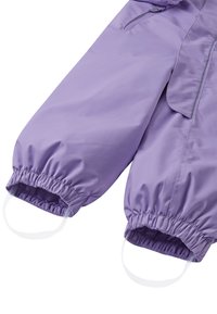 Lilla polstret overall med elastiske mansjetter og løkker, som har et glatt, glinsende stoff og detaljer med glidelåslommer.