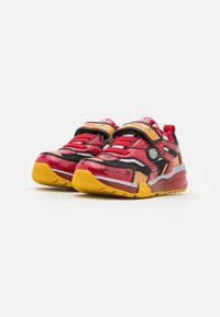Rote und orange Sportchuhe aus Mesh- und Synthetikmaterialien, mit schwarzen Akzenten, einem Klettverschluss und einer gelben Gummisohle.