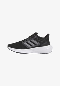 Scarpa sportiva nera con accenti grigi, parte superiore in rete, chiusura con lacci e una suola intermedia bianca prominente. Presenta tre strisce parallele sul lato.