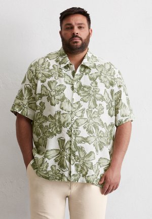 Short-sleeve shirt in light fabric featuring a green floral pattern on a white background; button-up front and loose fit with a casual cut.