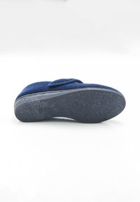 Zapatilla de casa azul marino con una parte superior de fieltro suave, una correa de gancho y bucle, y una suela de goma texturizada con patrones florales para mayor agarre.