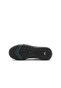 Semelle de chaussure de sport noire avec une texture en caoutchouc antidérapant, comportant un accent teal foncé et un motif en zigzag pour une meilleure traction, avec un logo près de l'arche.