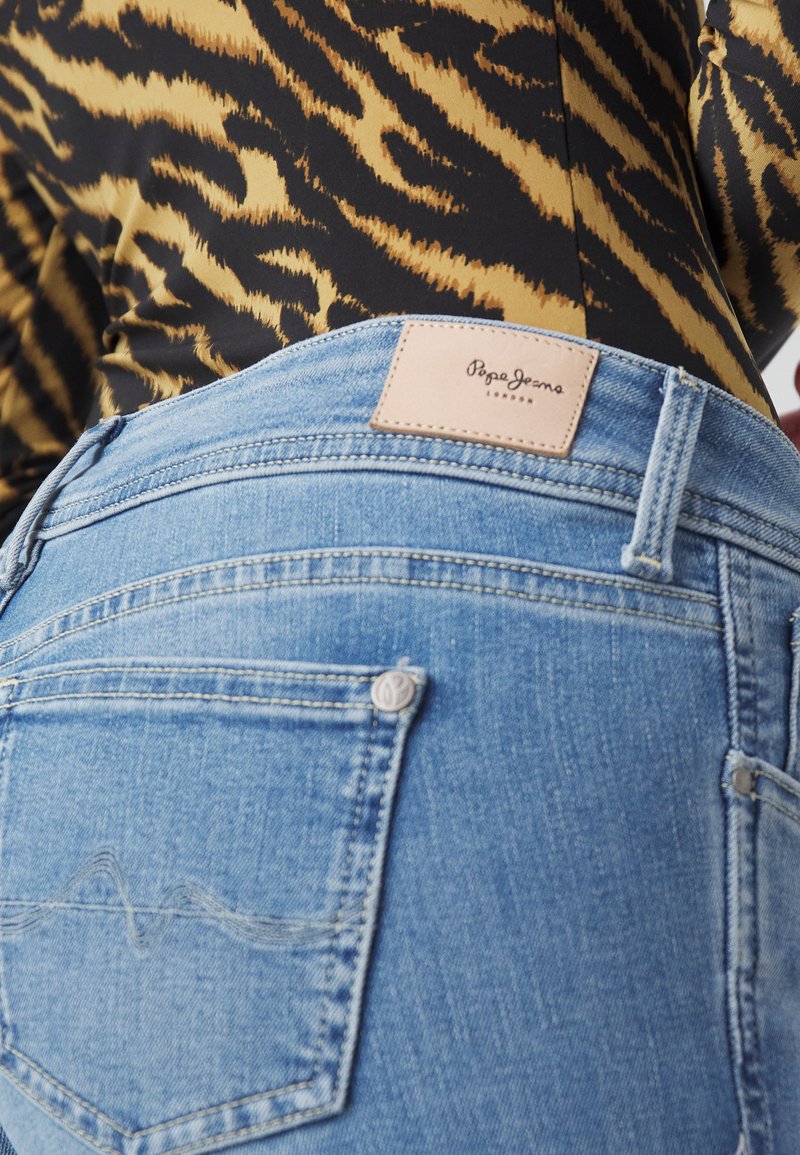 Jean bleu clair dotés d'une étiquette en cuir avec "Pepe Jeans London" et de subtils détails de couture sur les poches arrière.
