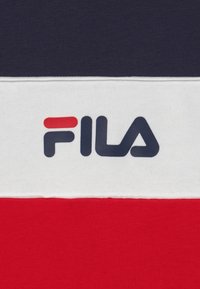 Felpa a strisce rossa, bianca e blu navy con un grande logo "FILA" blu navy sulla fascia bianca. Materiale in cotone con una texture liscia.