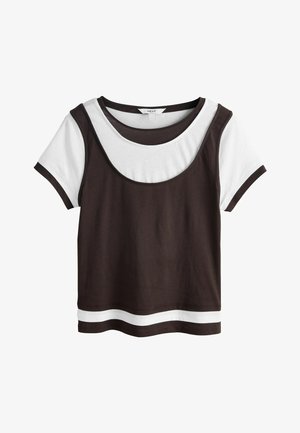Kortærmet lagdelt top med hvid bund og mørkebrun ærmeløs overdel, med kontrasterende striber ved halsudskæring og kant.