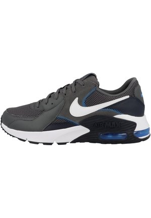 Harmaa urheilujalkaine, jossa on verkkomainen ja synteettinen päällinen, valkoinen swoosh-logo, siniset yksityiskohdat ja näkyvä ilmatiiviste pohjassa.