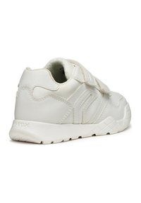 Sneaker bianca con una tomaia in pelle liscia, cinturini in velcro, dettagli testurizzati e una suola in gomma con motivo a griglia.