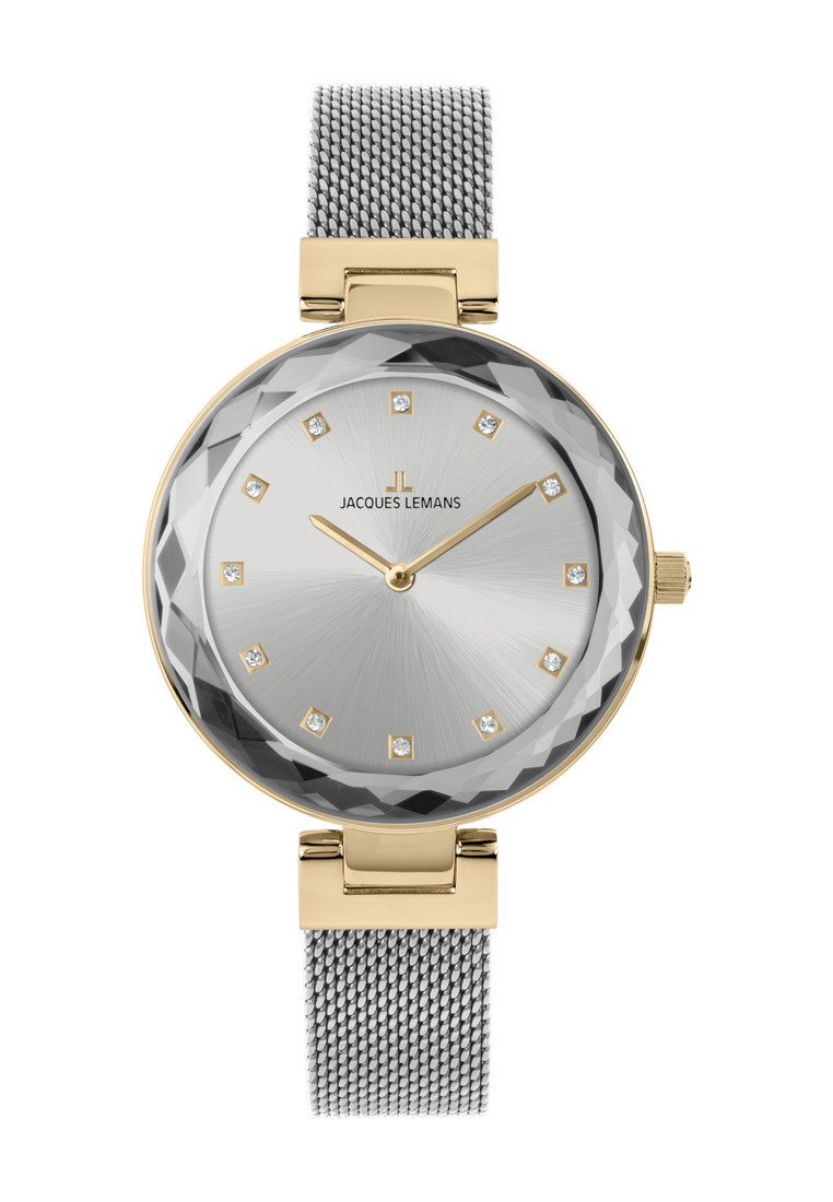 Reloj plateado redondo con cristal facetado, acentos dorados, correa de malla plateada, marcadores de hora minimalistas y logotipo de la marca en el centro.