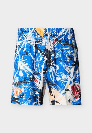 Blue shorts with white, black, red, and yellow paint splatter pattern, featuring Manchester United and Adidas logos on front.