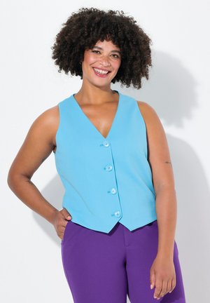Chaleco sin mangas de color azul claro con escote en V y cinco botones azules, combinado con pantalones morados, exhibido sobre un fondo blanco.