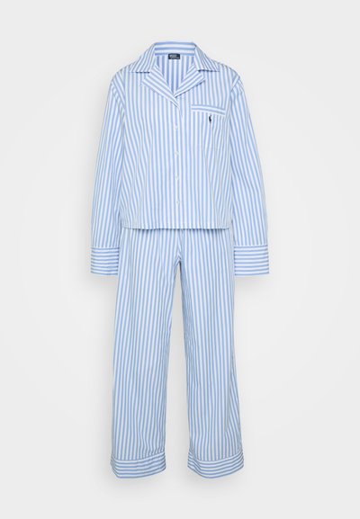 Randig pyjamas-set i ljusblått och vitt. Har lång ärm, knappstängd topp med ficka och matchande löst sittande byxor. Material av bomull.