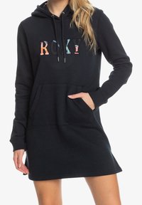 Robe à capuche noire avec poche kangourou, ornée d'un logo "ROXY" multicolore. Tissu doux, capuche avec cordon de serrage et poignets côtelés.
