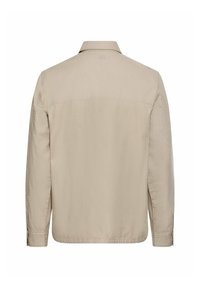Chemise beige décontractée à manches longues avec poignets boutonnés, vue de dos sur fond blanc.