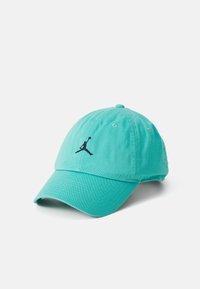 Türkise Baumwoll-Baseballmütze mit gebogenem Schirm, ausgestattet mit einem schwarzen Jumpman-Logo auf der Vorderseite und Belüftungsöffnungen.
