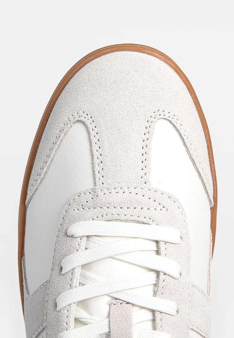 Weiße Ledersneaker mit grauen Wildlederakzenten, runder Zehenpartie, Gummisohle und flachen weißen Schnürsenkeln. Verfügt über Steppnähte im Obermaterial.
