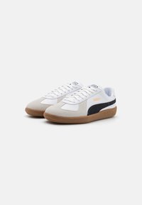 Baskets en cuir blanc et en daim gris avec des accents noirs, lacets plats et semelles en caoutchouc gomme. Logo sur la languette et sur le côté.